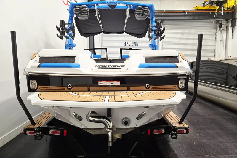 Slide: The Image of 2026 Nautique Super Air Nautique GS20 boat, rear view in a showroom setting. - 5