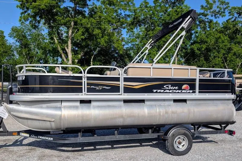 The Image of 2020 Sun Tracker Bass Buggy 18 Classic pontoon boat on trailer, parked outdoors. - 1