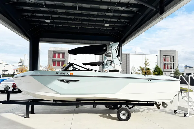 The Image of 2023 Nautique Super Air Nautique S25 boat on trailer under a canopy. - 1