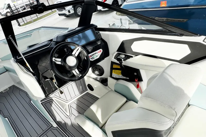 Slide: The Image of 2023 Nautique Super Air Nautique S25 boat interior with modern steering and dashboard. - 12