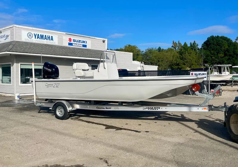 The Image of 2025 Coastal Skiff 212 boat on trailer outside Yamaha Suzuki dealership. - 0