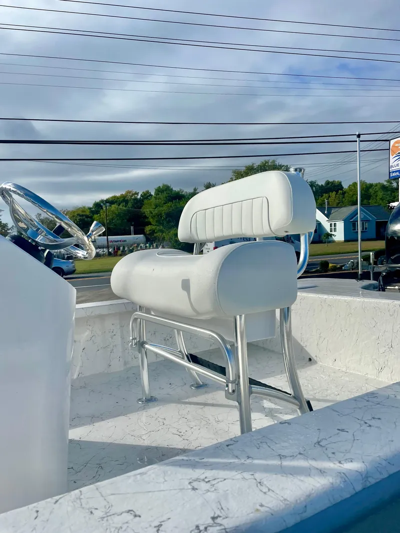 Slide: The Image of 2025 Coastal Skiff 212 boat interior with white seating and steering wheel. - 3