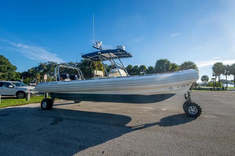 Slide: The Image of 2023 Ocean Craft 38 boat with wheels on a sunny day, parked near palm trees. - 10