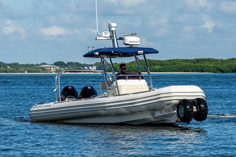 Slide: The Image of 2023 Ocean Craft 38 boat cruising on a sunny day with lush greenery in the background. - 18