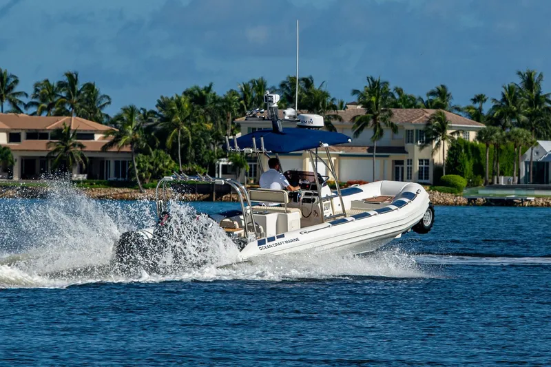 Slide: The Image of 2023 Ocean Craft 38 boat cruising on a sunny day near waterfront homes. - 22