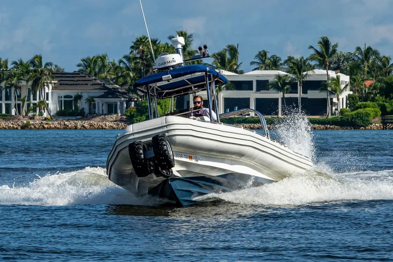 Slide: The Image of 2023 Ocean Craft 38 boat cruising on water near luxury waterfront homes. - 23