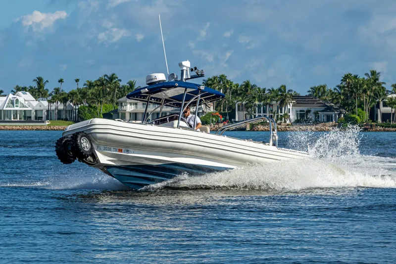 Slide: The Image of 2023 Ocean Craft 38 boat cruising on water near luxury waterfront homes. - 24