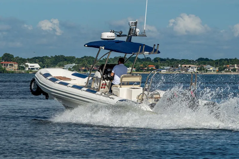 Slide: The Image of 2023 Ocean Craft 38 boat cruising on water, creating splashes, with scenic background. - 25