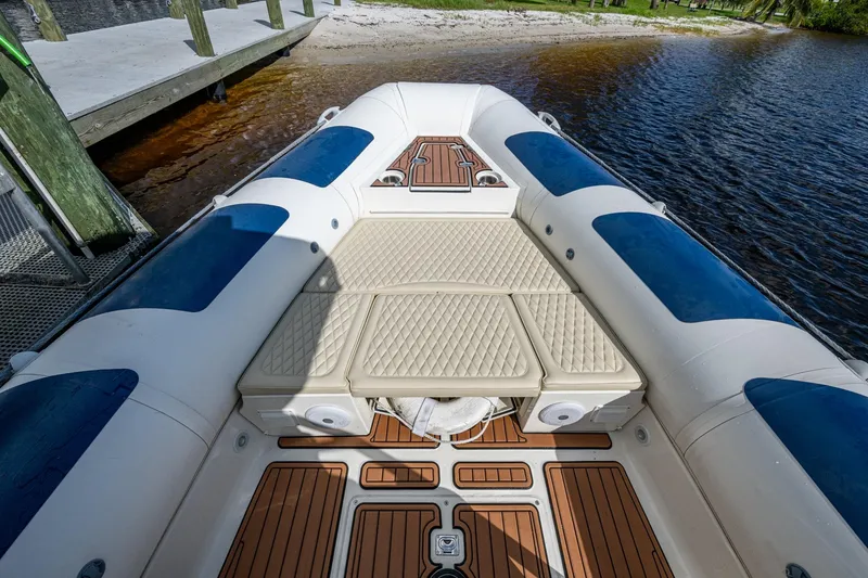 Slide: The Image of 2023 Ocean Craft 38 boat with cushioned deck, docked by the water. - 5
