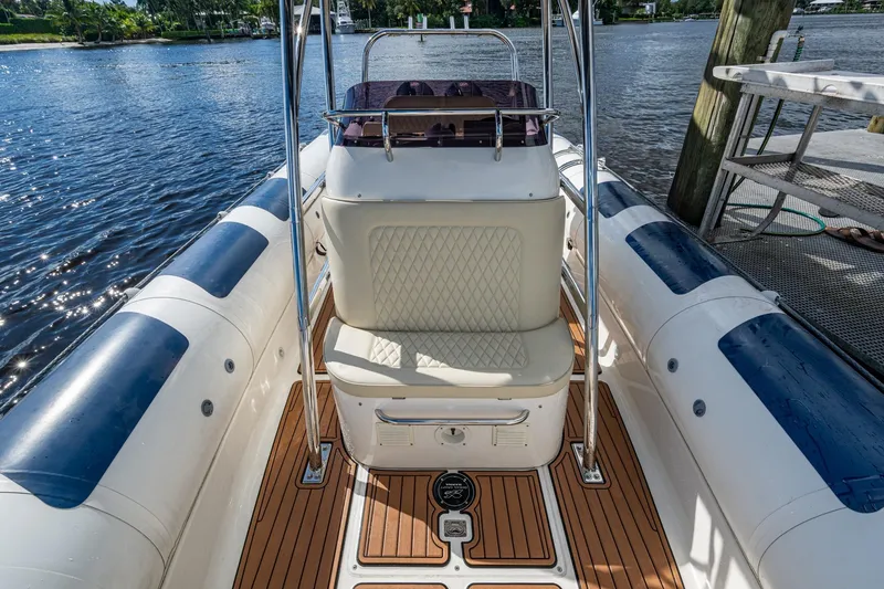 Slide: The Image of 2023 Ocean Craft 38 boat interior with cushioned seating and teak flooring by the water. - 8