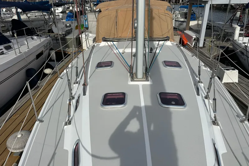 Slide: The Image of 2006 Catalina 387 sailboat deck view at marina, featuring hatches and rigging. - 17