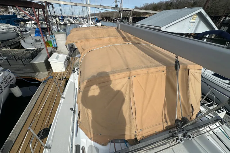 Slide: The Image of 2006 Catalina 387 sailboat with tan canvas cover docked at marina. - 18