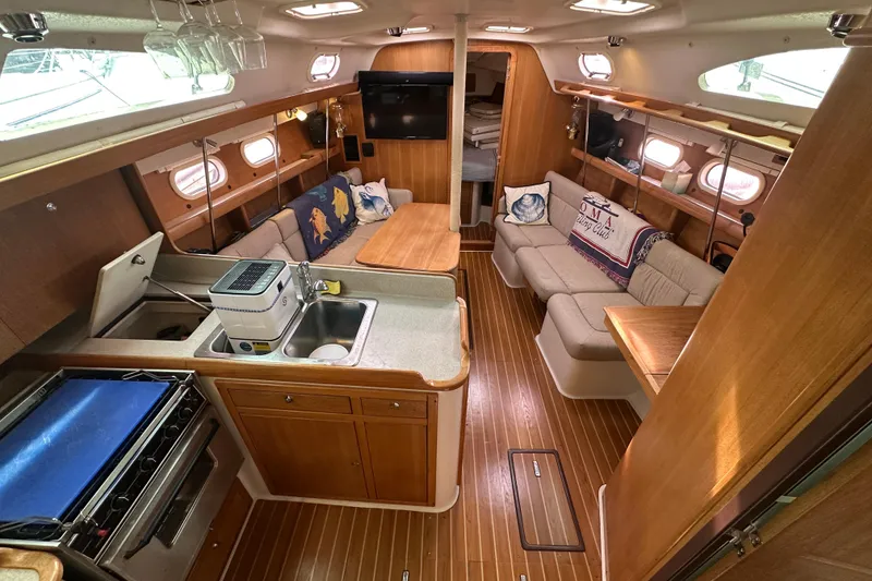 Slide: The Image of Interior of 2006 Catalina 387 yacht with cozy seating, kitchen, and wooden finishes. - 19