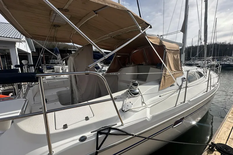 Slide: The Image of 2006 Catalina 387 sailboat docked, featuring tan canopy and sleek white design. - 3