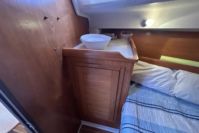 Slide: The Image of Cozy cabin interior of 2006 Catalina 387 sailboat with wooden cabinetry and bedding. - 31