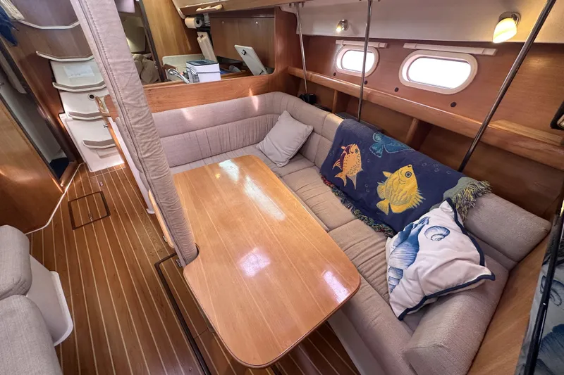 Slide: The Image of Cozy interior of 2006 Catalina 387 sailboat with wooden table and cushioned seating. - 32