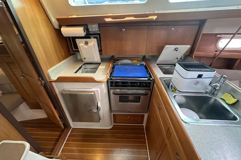 Slide: The Image of Compact kitchen in a 2006 Catalina 387 sailboat with stove, sink, and storage. - 34