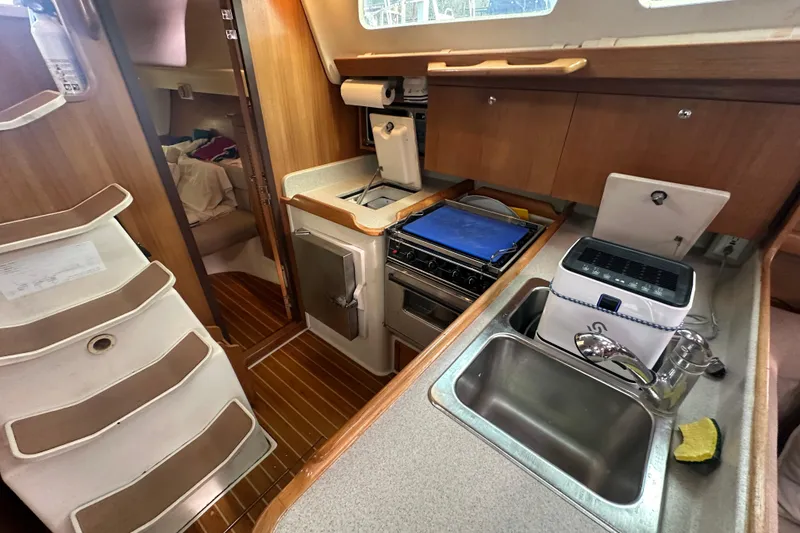 Slide: The Image of Interior of 2006 Catalina 387 sailboat featuring kitchen and cozy cabin area. - 35