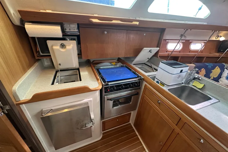 Slide: The Image of 2006 Catalina 387 yacht kitchen with stove, sink, and wooden cabinetry. - 36