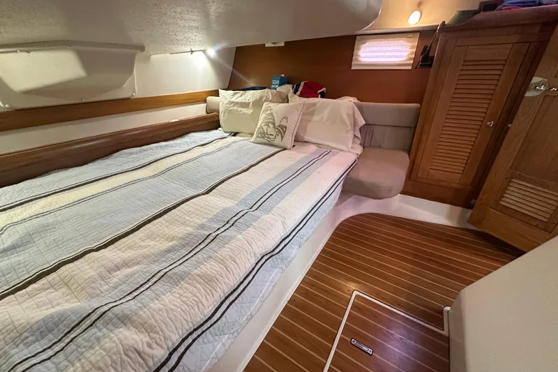 Slide: The Image of Cozy cabin interior of 2006 Catalina 387 sailboat with bed and wooden accents. - 41