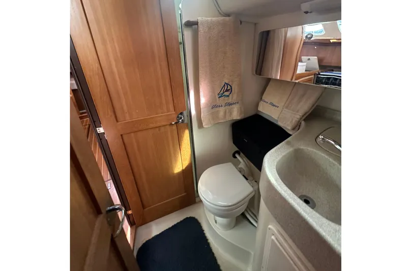 Slide: The Image of Compact bathroom in 2006 Catalina 387 sailboat with sink, toilet, and wooden door. - 46
