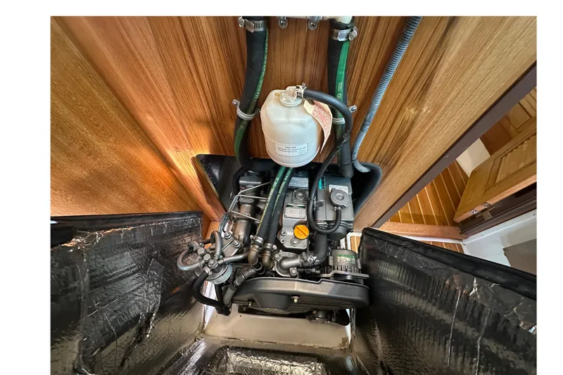 Slide: The Image of Engine compartment of a 2006 Catalina 387 sailboat, showcasing mechanical components and hoses. - 50