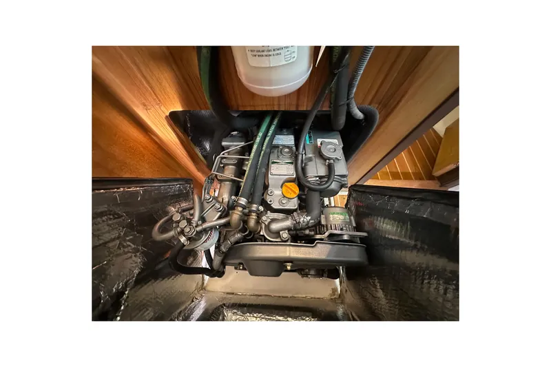 Slide: The Image of Engine compartment of a 2006 Catalina 387 sailboat, showcasing mechanical components and hoses. - 51