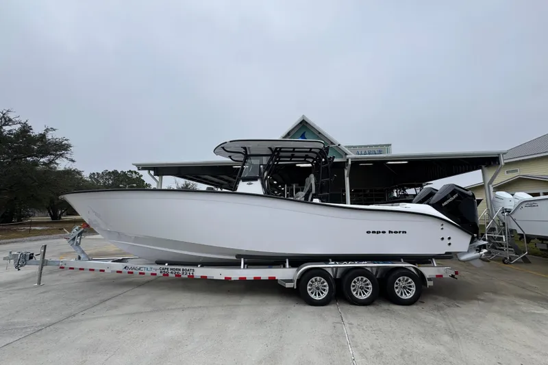 The Image of 2026 Cape Horn 32 XS boat on trailer, parked outdoors near a marina. - 1
