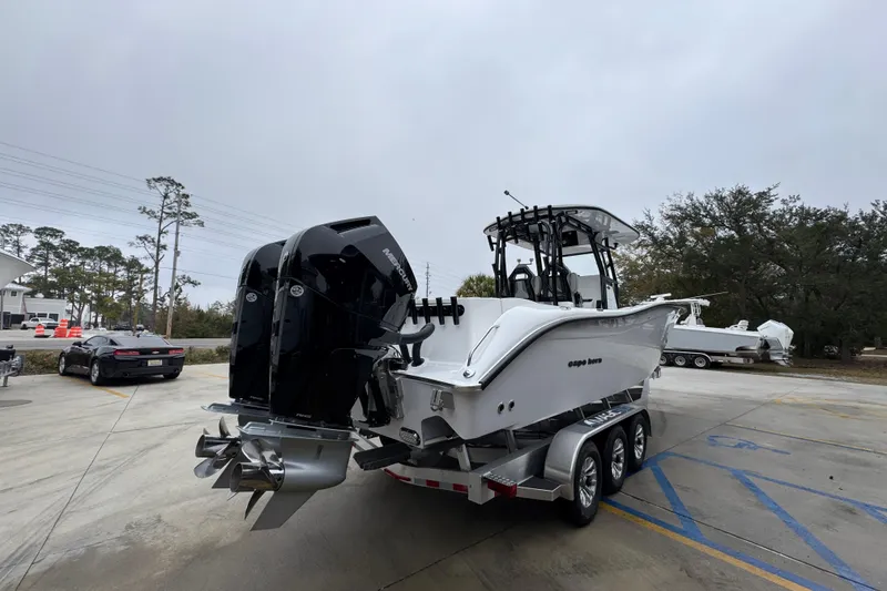 Slide: The Image of 2026 Cape Horn 32 XS boat on trailer with dual outboard motors in parking lot. - 11