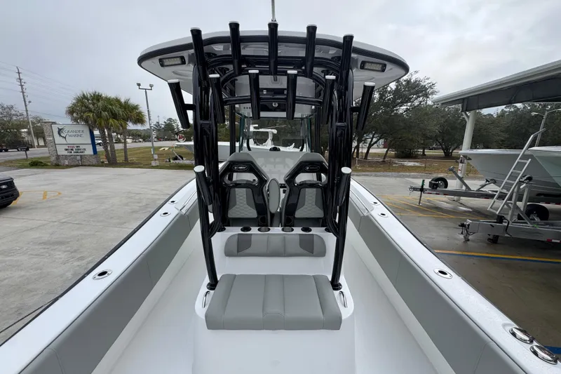 Slide: The Image of 2026 Cape Horn 32 XS boat interior with seating and rod holders, parked outdoors. - 37