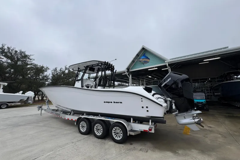 Slide: The Image of 2026 Cape Horn 32 XS boat on trailer, parked outside a marina. - 16