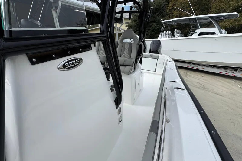 Slide: The Image of 2026 Cape Horn 32 XS boat, sleek design, white exterior, modern seating, docked outdoors. - 24