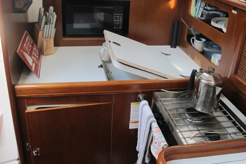 Slide: The Image of Galley kitchen in 2000 Beneteau Oceanis 361 sailboat with stove, microwave, and storage. - 22