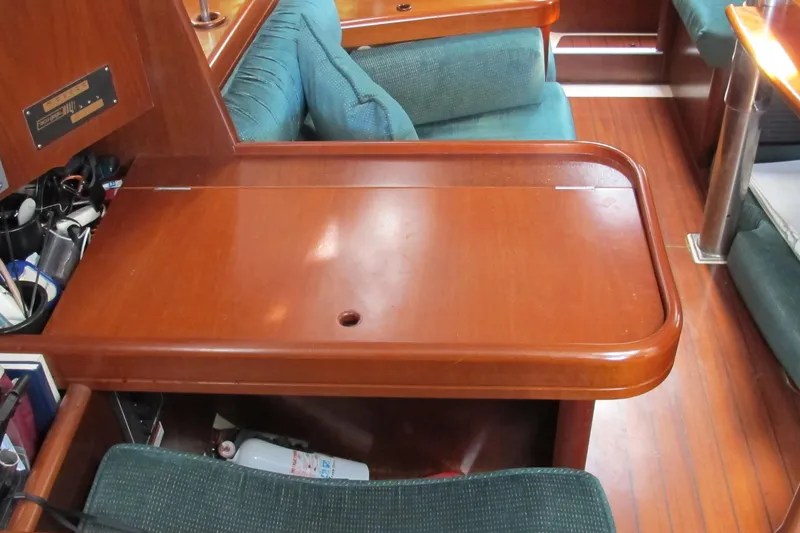 Slide: The Image of Interior of 2000 Beneteau Oceanis 361 yacht with wooden table and green seating. - 28