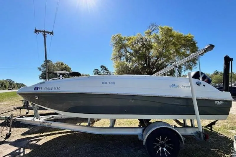 Slide: The Image of 2019 Hurricane SunDeck Sport 188 OB boat on trailer under clear blue sky. - 4