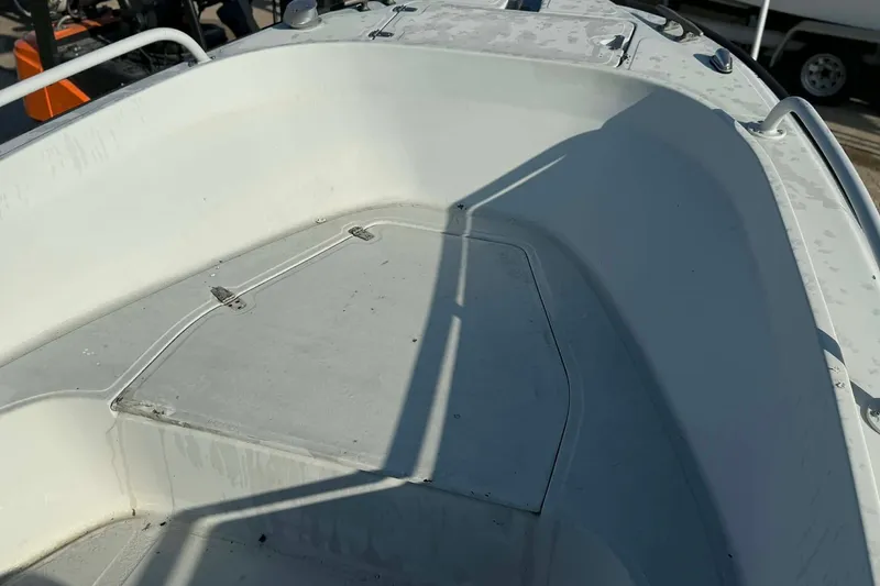 Slide: The Image of 2000 Boston Whaler Justice 24 boat interior with storage compartment and railing. - 10