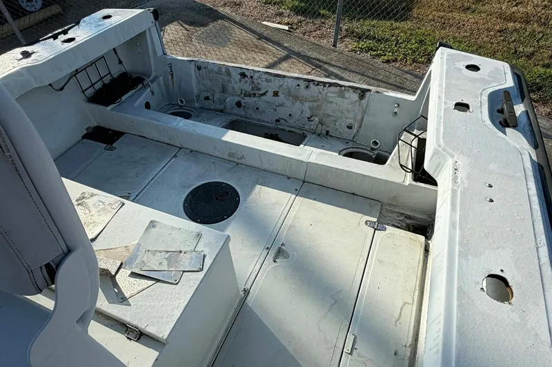 Slide: The Image of 2000 Boston Whaler Justice 24 boat interior, showing spacious, weathered deck and seating area. - 3