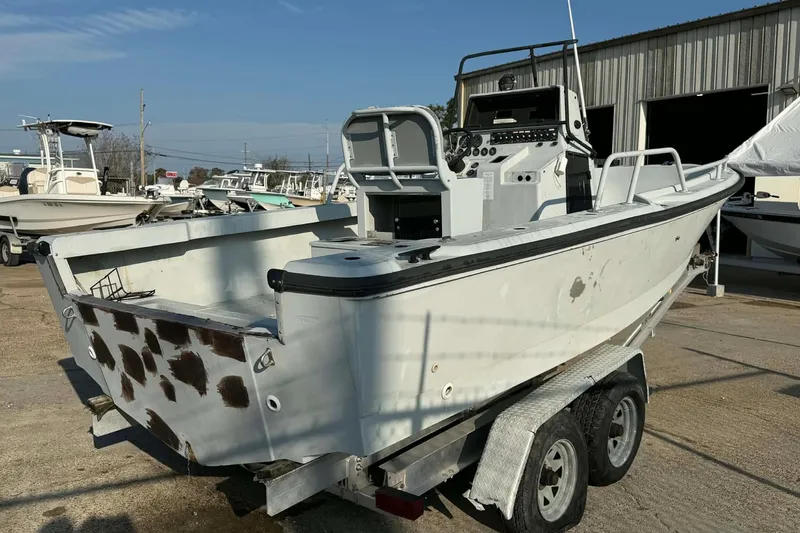Slide: The Image of 2000 Boston Whaler Justice 24 boat on trailer, in a marina setting. - 4
