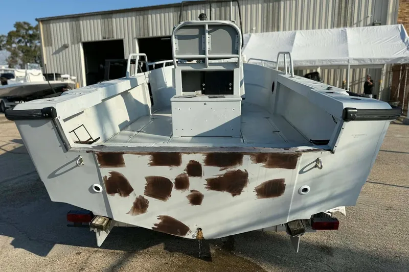 Slide: The Image of 2000 Boston Whaler Justice 24 boat, rear view, in a boatyard setting. - 6