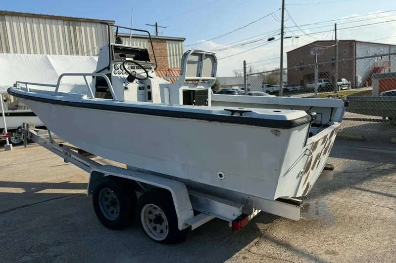 Slide: The Image of 2000 Boston Whaler Justice 24 boat on trailer in industrial setting. - 9