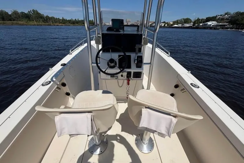 Slide: The Image of 2002 KenCraft Challenger 180 boat interior with dual seats and steering console on water. - 10