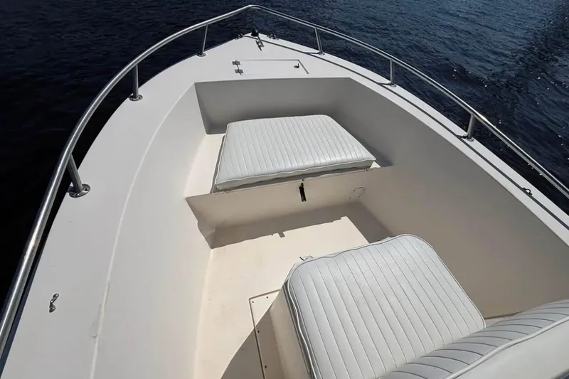 Slide: The Image of 2002 KenCraft Challenger 180 boat interior with cushioned seating, on calm water. - 5