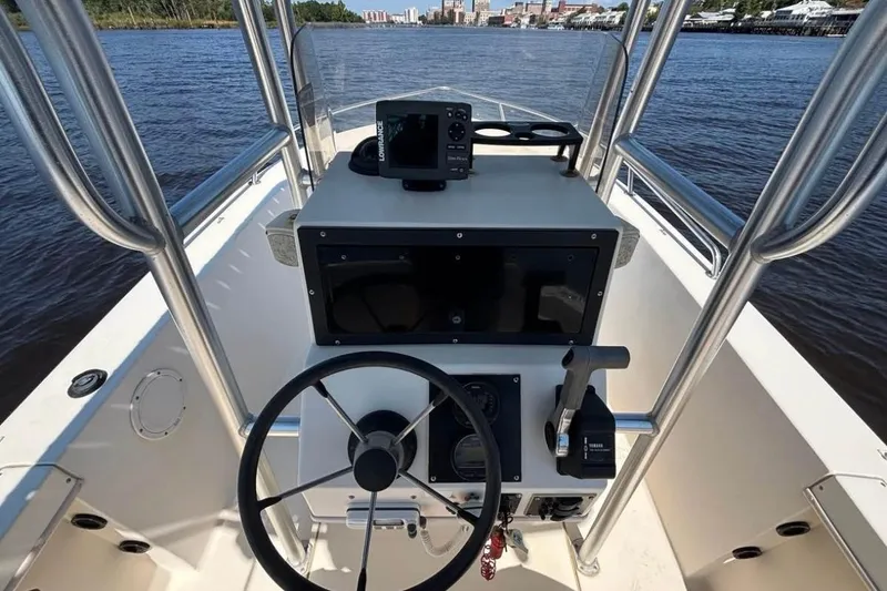 Slide: The Image of 2002 KenCraft Challenger 180 boat console with steering wheel and navigation equipment on a river. - 9