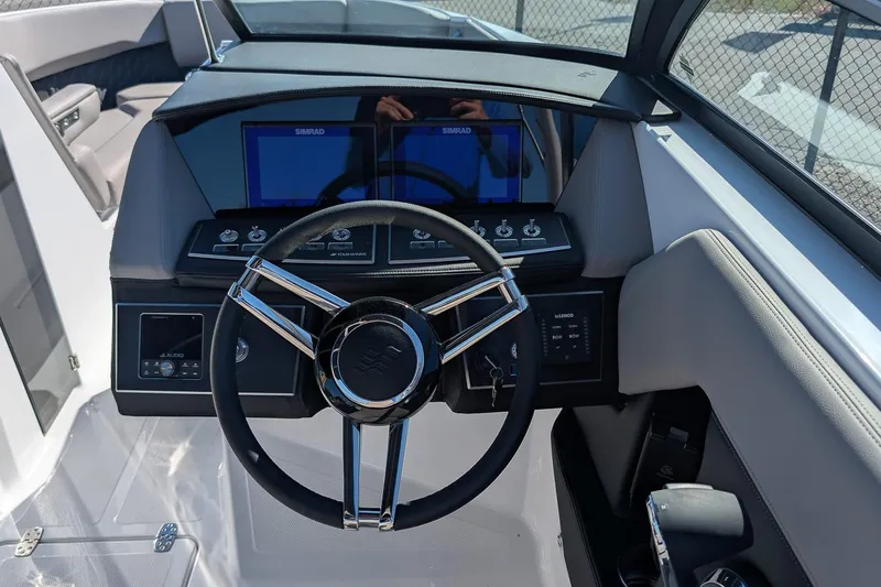 Slide: The Image of 2026 Four Winns H6 OB boat dashboard with steering wheel and digital displays. - 14