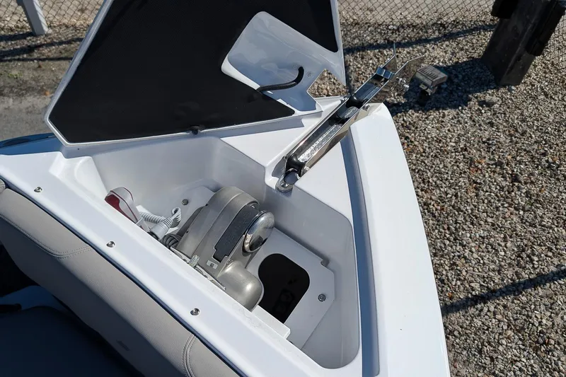 Slide: The Image of 2026 Four Winns H6 OB boat anchor compartment with open hatch, showing anchor mechanism. - 22