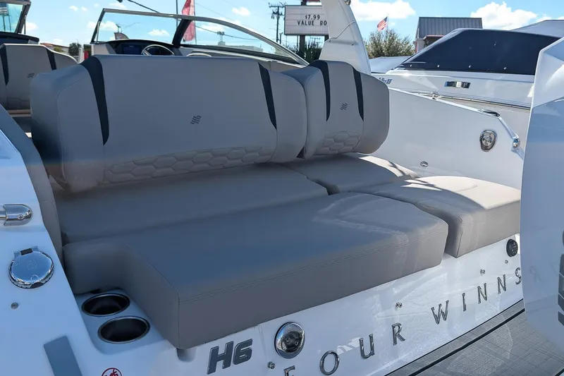 Slide: The Image of 2026 Four Winns H6 OB boat interior with gray seating and cup holders. - 4