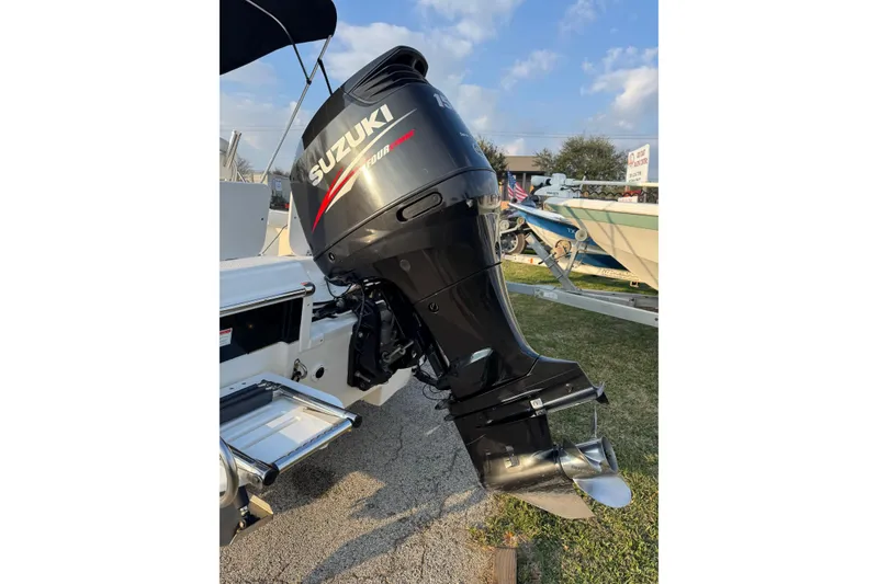 Slide: The Image of 2012 Carolina Skiff 21 Ultra Elite with Suzuki outboard motor, parked on grass. - 14