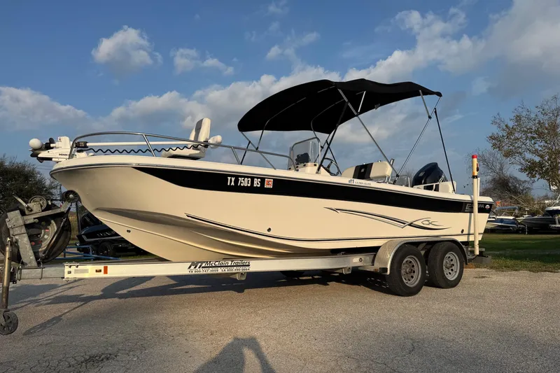 Slide: The Image of 2012 Carolina Skiff 21 Ultra Elite boat on trailer, parked outdoors under blue sky. - 15