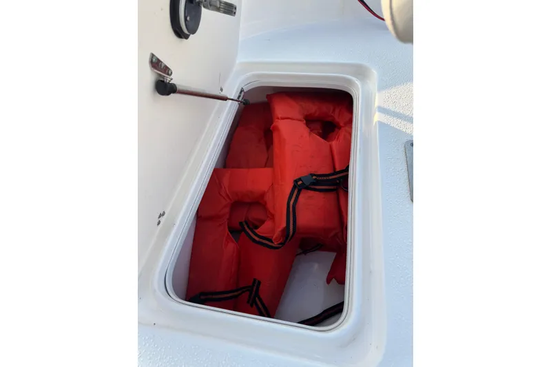 Slide: The Image of Storage compartment with life jackets on a 2012 Carolina Skiff 21 Ultra Elite boat. - 8