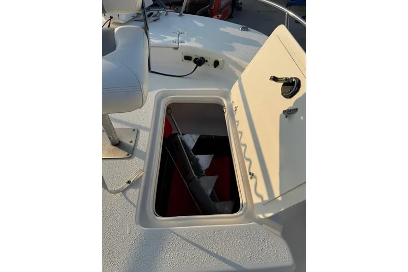 Slide: The Image of 2012 Carolina Skiff 21 Ultra Elite boat storage compartment open on deck. - 9